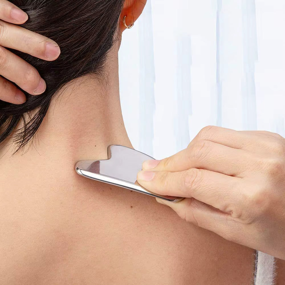 Person using SkinSculpt™ stainless steel Gua Sha tool to massage the neck and trapezius muscles, relieving tension and promoting relaxation