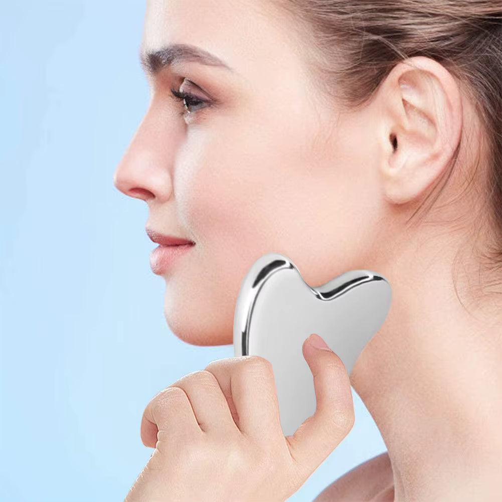 Side profile of woman using SkinSculpt™ stainless steel Gua Sha tool to massage her face for improved circulation and skin health