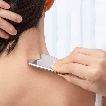 Person using SkinSculpt™ stainless steel Gua Sha tool to massage the neck and trapezius muscles, relieving tension and promoting relaxation